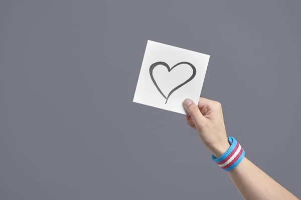 Young Hand Holding Paper Hand Drawn Heart Wearing Transgender Flag — Zdjęcie stockowe