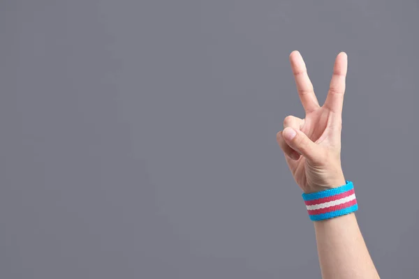 Young Hand Making Victory Peace Sign Wearing Transgender Flag Bracelet — Zdjęcie stockowe