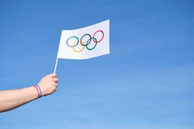 Açık havada, açık havada el yapımı Olimpiyat Oyunları bayrağını tutan, mavi, beyaz ve kırmızı bir bilezik takan, Fransa ulusal bayrağının renkleri. Kopyalama alanı olan resim.