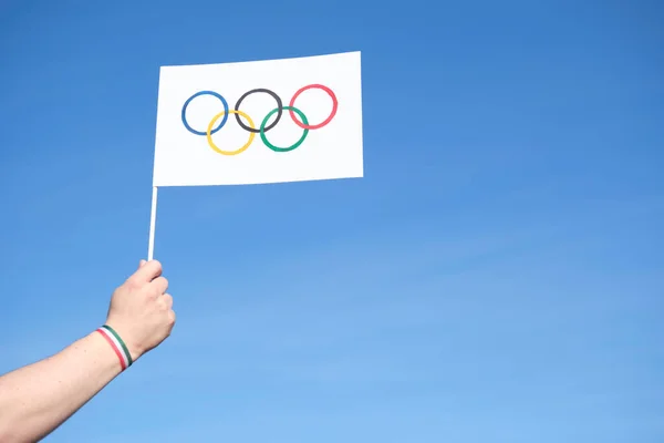 Tangan Memegang Bendera Olimpiade Luar Ruangan Buatan Tangan Melawan Langit — Stok Foto