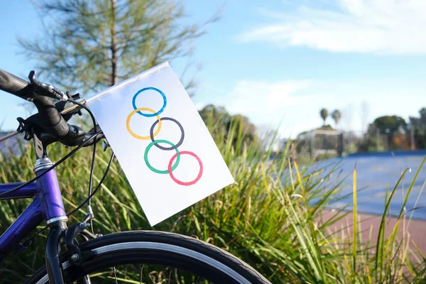 Hemgjorda Olympiska Flagga Papper Sätta Framsidan Cykel Utomhus Idrottsmiljö Solig — Stockfoto