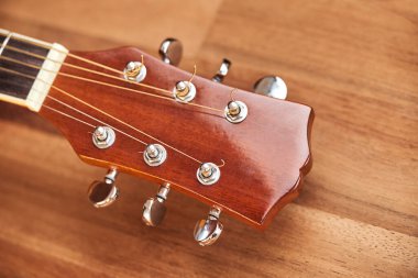 Tahta bir yüzeyde gitar başlığı. Yatay resmi kapat.