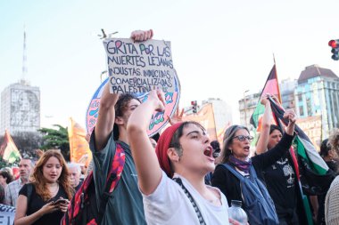 Buenos Aires, Argentina; October 7, 2025: massive protest in support of Palestinian people. Sign: Cry out for the distant, unjust, induced, commercialized deaths. Free Palestine!