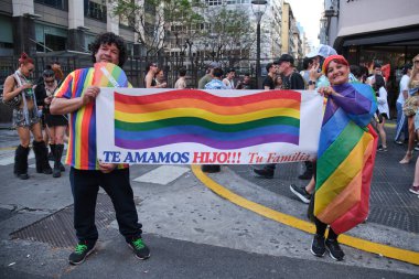 1 Kasım 2025 Buenos Aires, Arjantin Onur Yürüyüşü, mesaj taşıyan gökkuşağı bayrağı taşıyan çift, seni seviyoruz, evlat! Ailen..