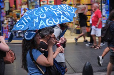 Buenos Aires, Arjantin; 7 Şubat 2026: Buzul Kanunu 'nun değiştirilmesini protesto. Protestocular üzerinde mesaj yazan mavi bir şemsiye tutuyorlar: Buzullar olmadan, su da olmaz..