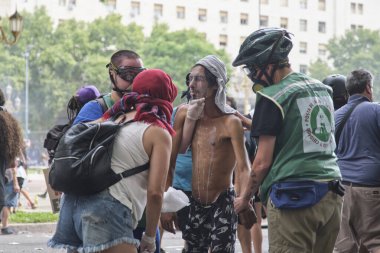 11 Şubat 2026, Buenos Aires, Arjantin: Senato 'da aynı gün işçi reformuna karşı yapılan büyük protesto. Sağlık ve Bakım Merkezi 'nden insanlar göz yaşartıcı gazdan etkilenen protestoculara yardım ediyor.