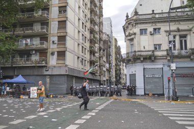11 Şubat 2026 'da Buenos Aires, Arjantin' de aynı gün Senato 'da yapılan iş reformunu protesto etti. Bir protestocu, elinde Filistin bayrağı sallayan polis memurlarının önünde yürüyor..