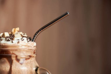 Çikolatalı milkshake 'in içinde yeniden kullanılabilir çevre dostu metal pipet. Resmi kopyalama alanı ile kapat. Kavramları: gastronomi, ekoloji, tek kullanımlık plastiklerin azaltılması.