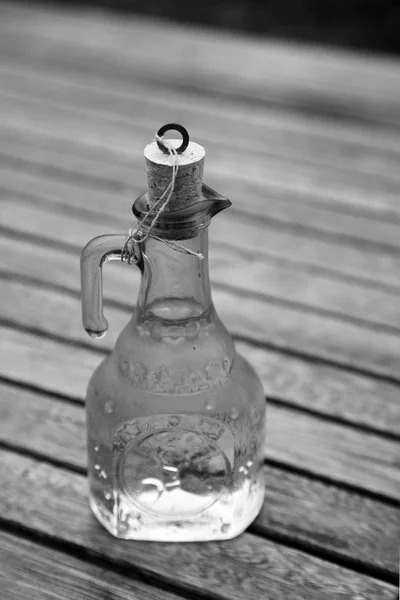 Aceite de oliva y rama de olivo sobre la mesa de madera —  Fotos de Stock