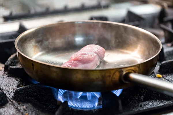 Cozinhar carne em uma panela de ato de fritar — Fotografia de Stock