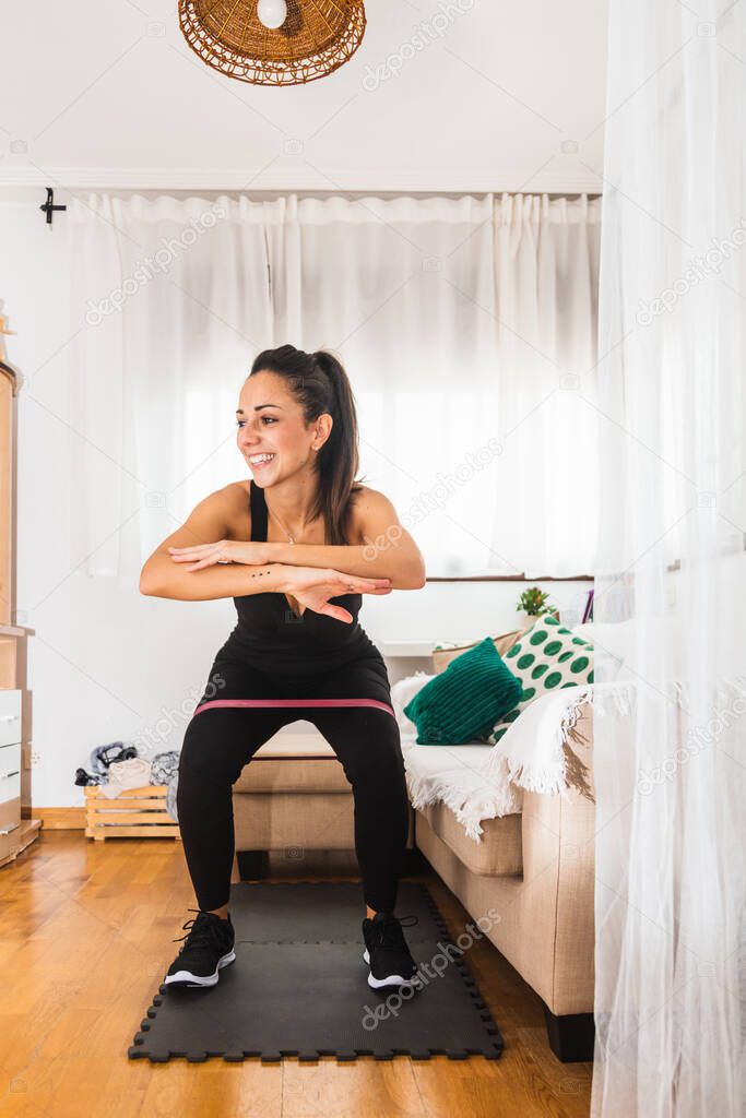 young happy woman exercising at home with a stripe