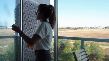 Pencereleri temizleyen genç kadın