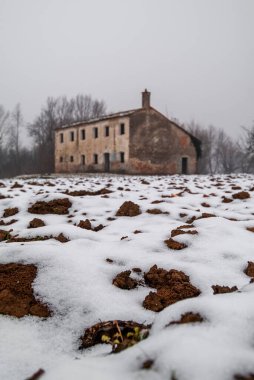 Issız eski bir kır evi ile karlı bir manzara