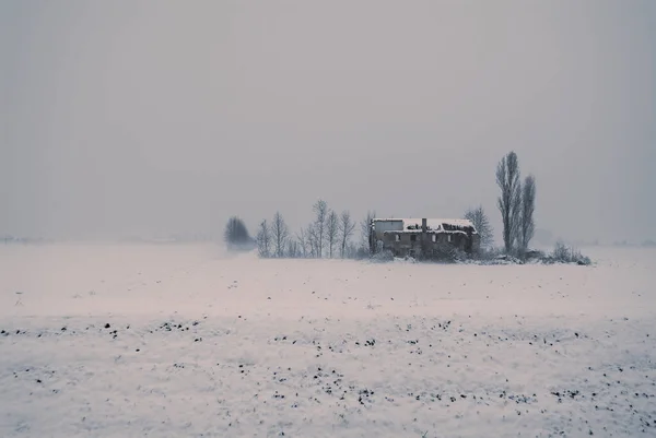 Paisagem nevada com uma antiga casa de campo desabitada — Fotografia de Stock