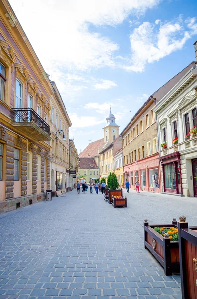 Arka planda bir kilise ile eski şehir merkezinde Braşov Yaya Caddesi