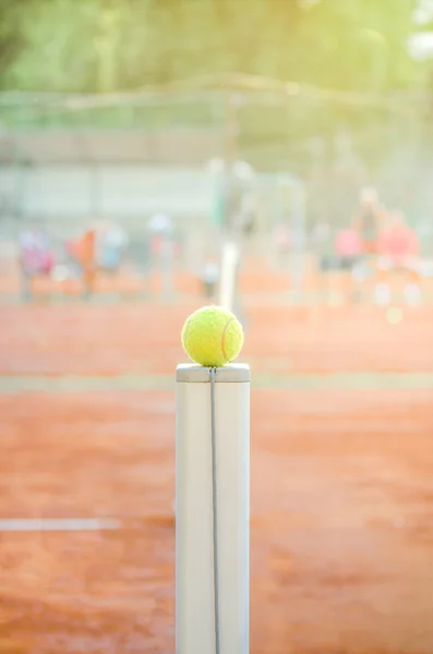 Tennis ball on the net post — Stock Photo, Image