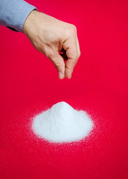 Salt sprinkled on a red dangerous background suggesting health concerns — 스톡 사진