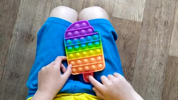 Niño Pantalones Cortos Azules Jugar Con Colorido Juguete Poppit Fidget — Vídeo de stock