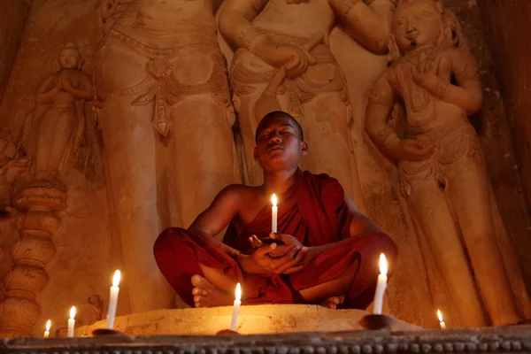 Буддійський чернець в молитві при свічках — стокове фото