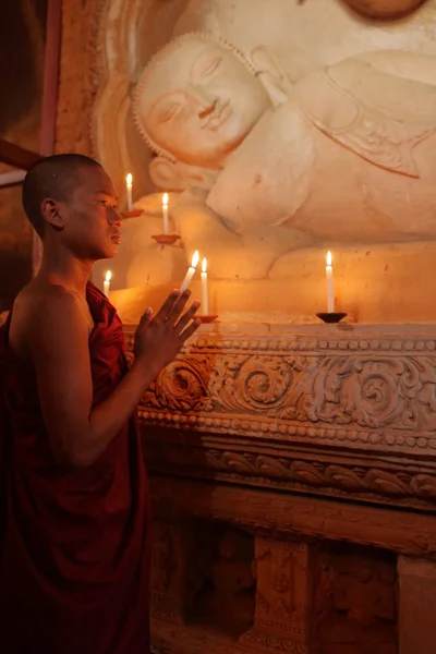 Monje budista en oración a la luz de las velas — Foto de Stock