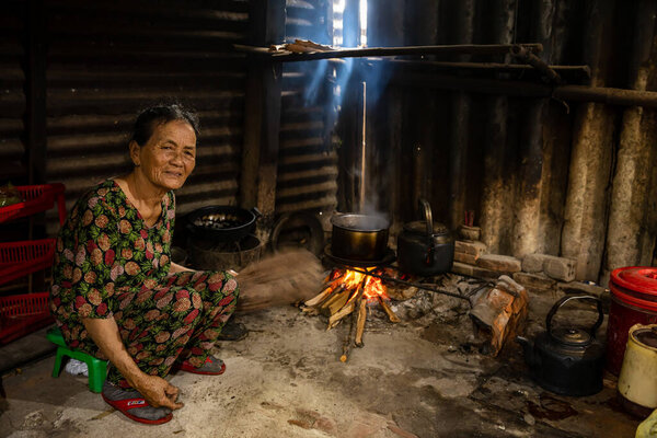 Vietnamese Woman at the fireplace in the kitchen