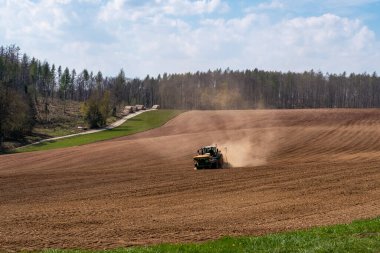 Sahadaki traktör kuru arazi yüzünden toz içinde.