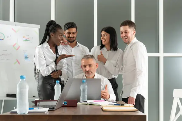 Erkek takım lideri çeşitli meslektaşlarının sorularını dinliyor, ofiste birlikte oturuyorlar. Karışık ırk genç takım arkadaşları beyin fırtınası toplantısında proje detaylarını tartışıyor