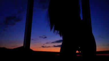 Gün batımında Panoramik Pencere Altında Dans Eden Kadın