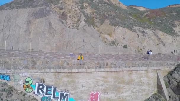 Eine Person vor einem Gebäude mit einem Berg im Hintergrund — Stockvideo