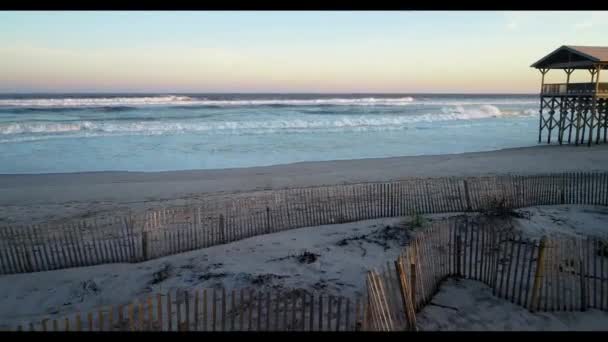 Uma praia de areia ao lado de um corpo de água — Vídeo de Stock