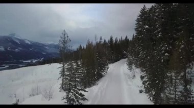 Karla kaplı dağda kayak yapan bir adam.