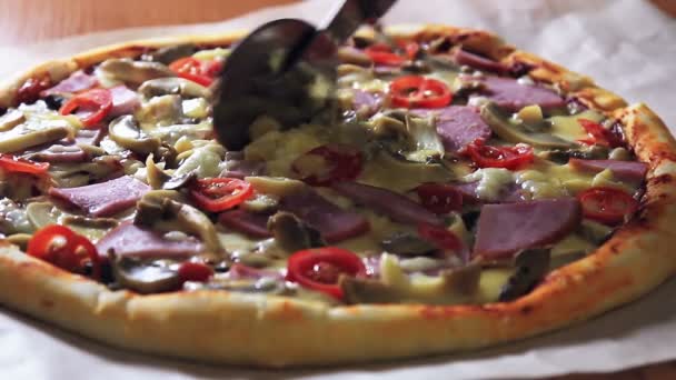 Une pizza assise sur une planche à découper en bois — Video