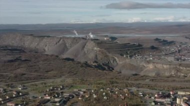 Arkasında dağ olan büyük bir bina.