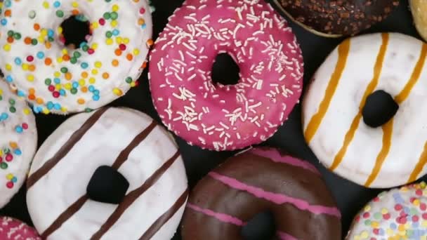 Een roze doos gevuld met verschillende soorten donuts — Stockvideo