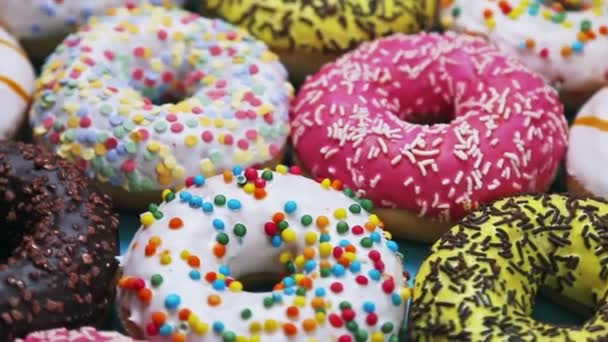 Een groep van verschillende gekleurde donuts — Stockvideo