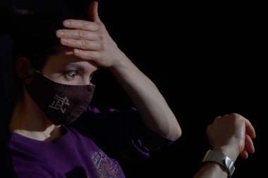 Maskeli güzel kız şaşkınlıkla el nöbetine bakıyor. Maskedeki Çince sembol WU-savaşçı.