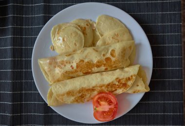 Masadaki beyaz tabakta sosisli gözleme.