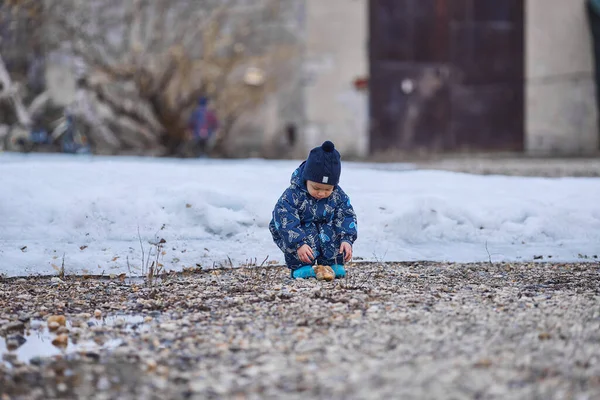 Un niño arroja piedras al agua —  Fotos de Stock