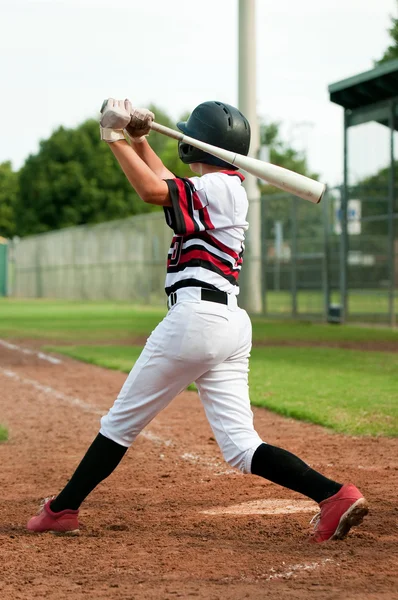 Jovem jogador de beisebol balançando morcego — Fotografia de Stock