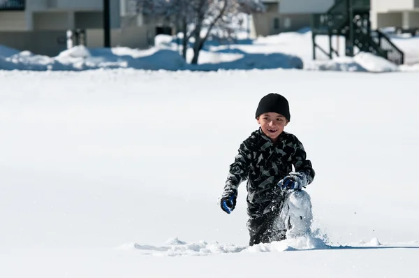 Netter Junge spielt im Schnee. — Stockfoto