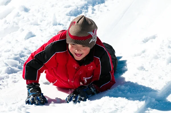 Leuke jongen in de sneeuw te leggen — Stockfoto