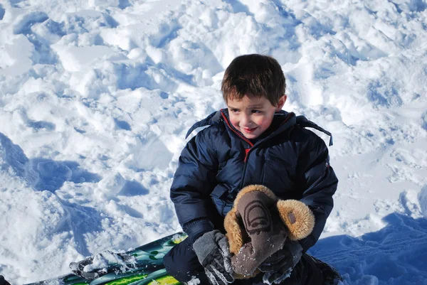 Mignon petit garçon jouant dans la neige à l'extérieur . — Photo