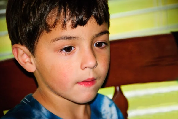 Close up of adorable little boy sitting in a chair. — Stock Photo, Image