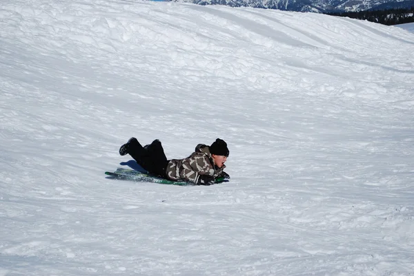 小孩坐雪橇滑下 snowhill. — 图库照片