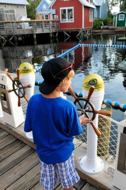 Küçük çocuk direksiyon tekne tekerlek eğlence parkı.