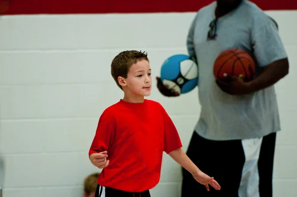 Ładny chłopczyk koszykówki podczas gry. — Zdjęcie stockowe