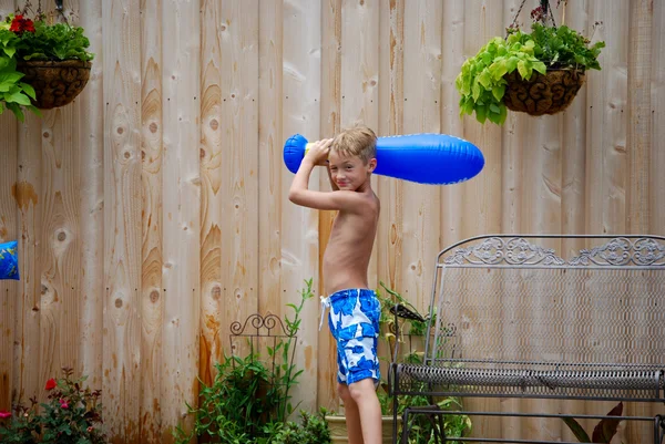 Junge hält aufblasbaren Baseballschläger in der Hand lizenzfreie Stockfotos
