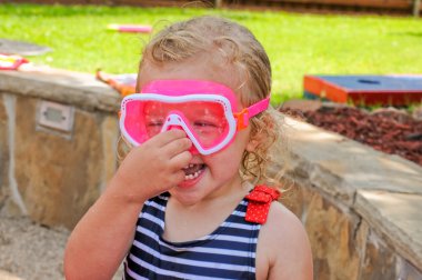 Sevimli küçük toddler pembe gözlükler ve mayo.