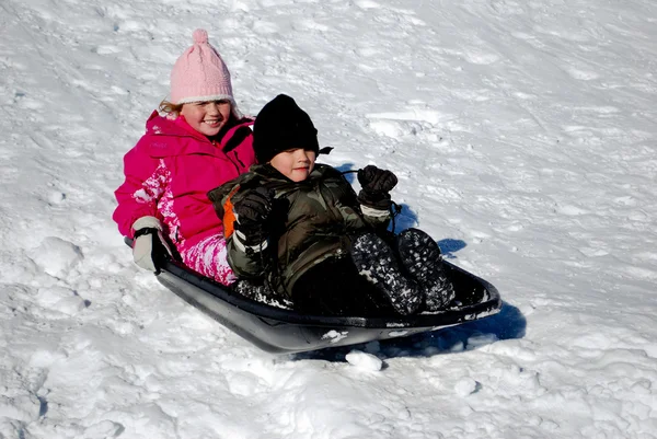 Deux enfants sur un traîneau à neige . — Photo