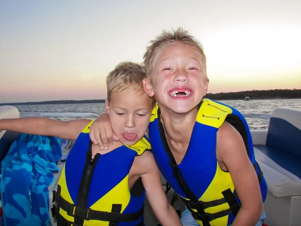 Two adorable boys on a lake at sunset. — Stock Photo, Image